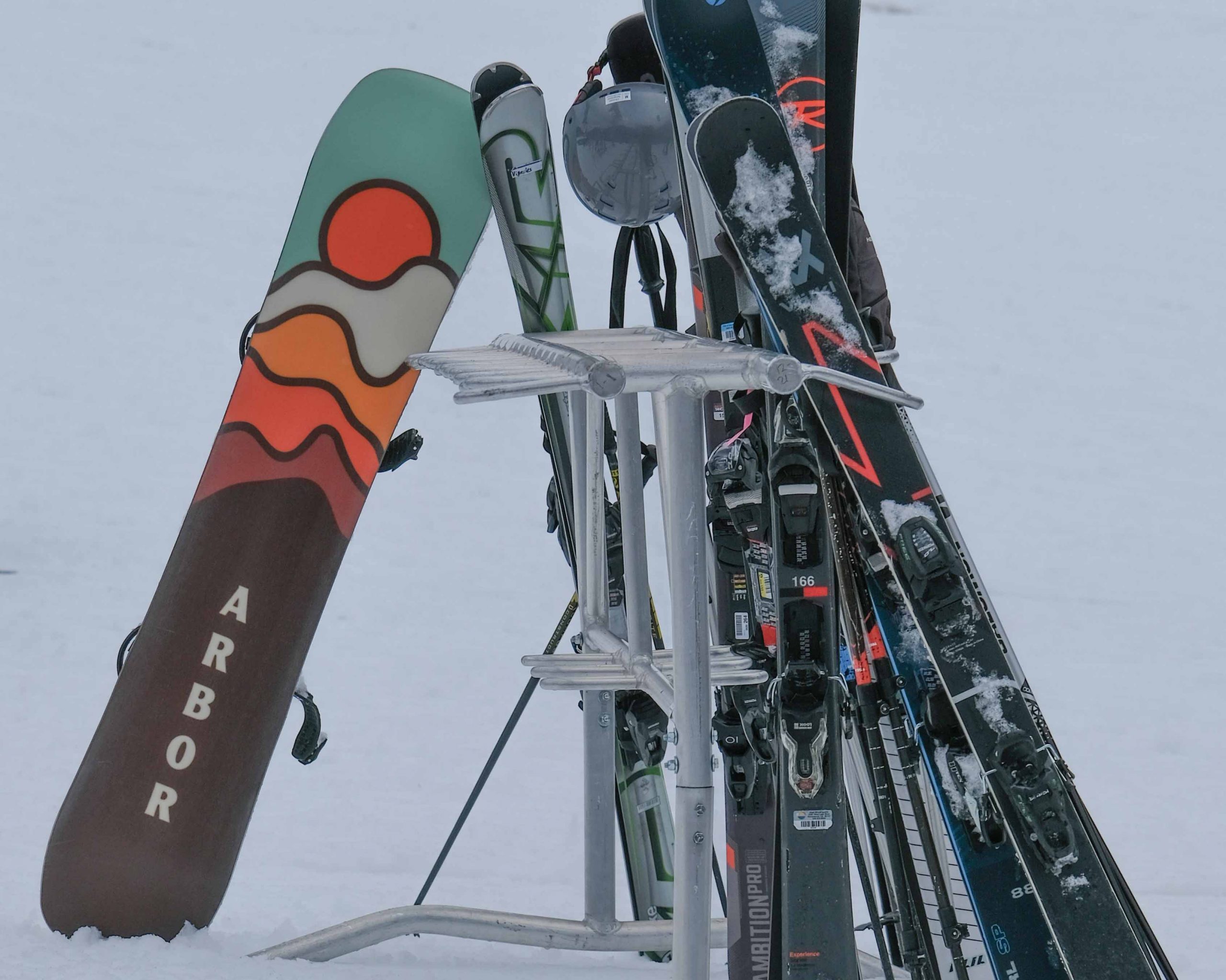 Titelbild für die Saisoneröffnungsfahrt nach Sölden 2025: Abgestellte Ski und ein Snowboard